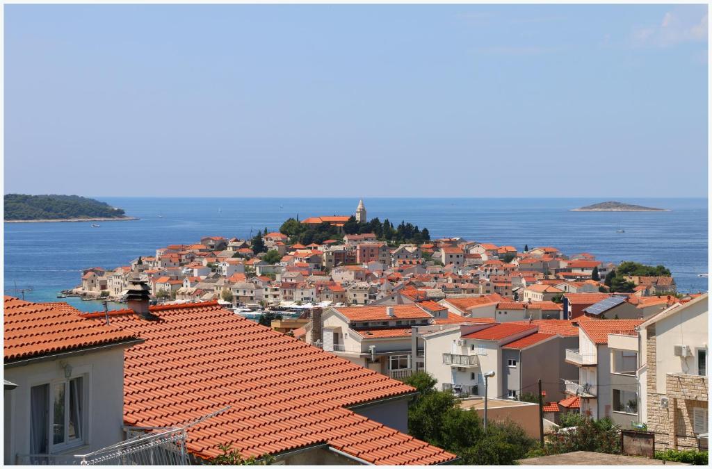 a view of a city with houses and the water at Apartmani Slavka in Primošten