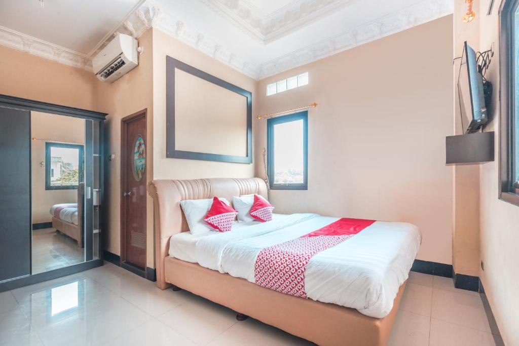 um quarto com uma cama com almofadas vermelhas em SUPER OYO 1640 Fallinda Hotel em Bogor