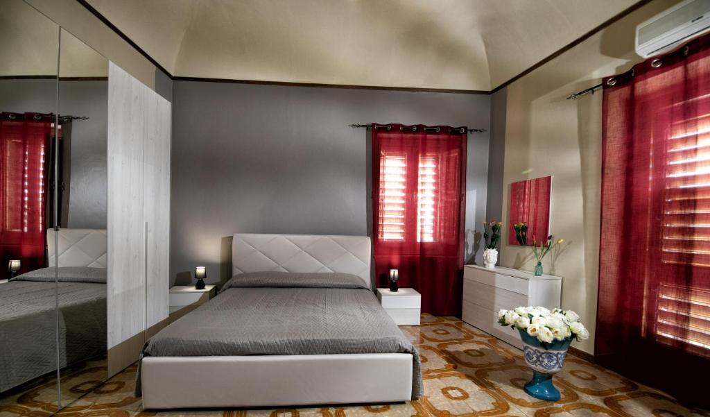 Schlafzimmer mit einem Bett und roten Vorhängen in der Unterkunft B&b Al Centro Nicosia in Nicosia
