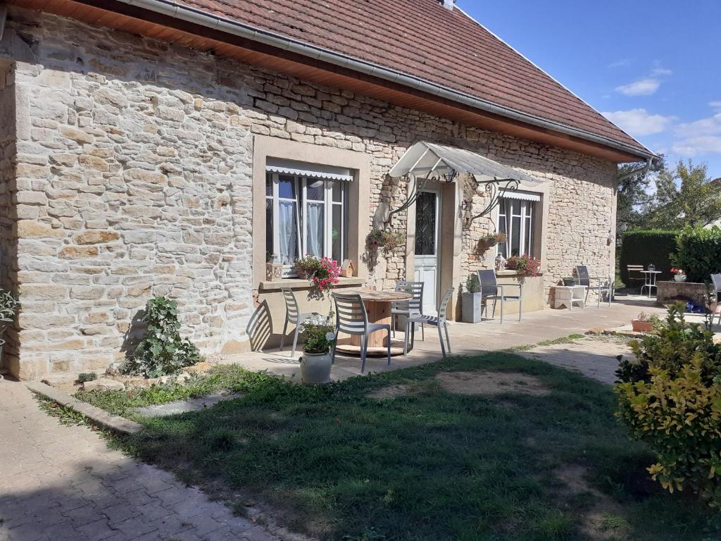 a brick building with a table and chairs outside at LES TROIS CHARMES in Chaucenne