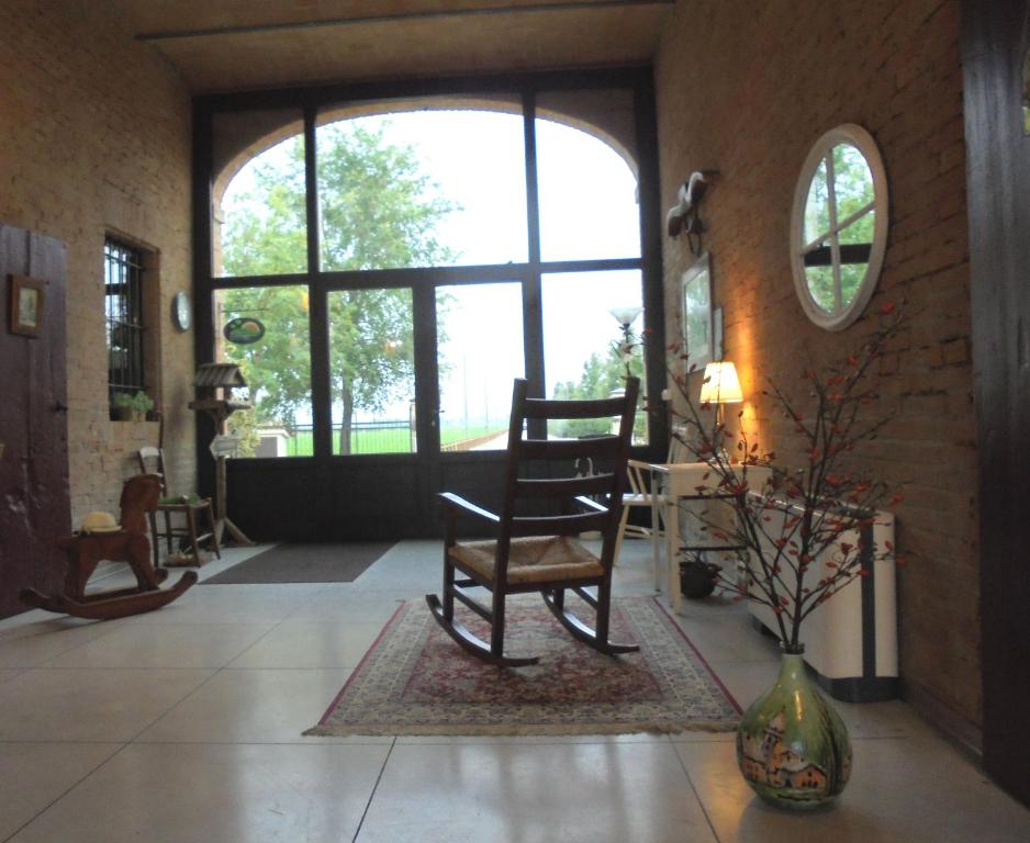 een kamer met een schommelstoel en een raam bij La Casa di Campagna in Reggio Emilia