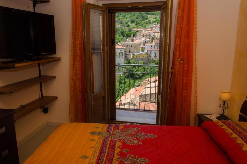 a bedroom with a window with a view of a city at B&B La Perla nelle Dolomiti in Castelmezzano