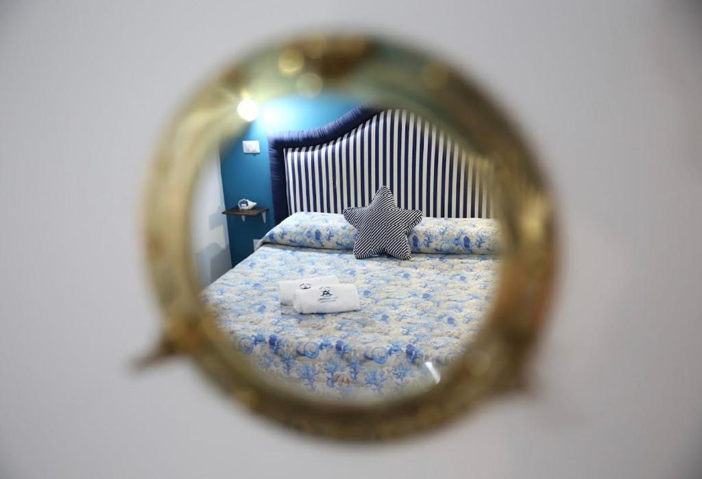 a mirror reflection of a bed in a bedroom at House SottoCoperta in Civitavecchia