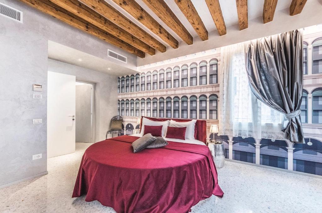 ヴェネツィアにあるRialto Luxury Flatのベッドルーム1室(赤いベッド1台、大きな窓付)