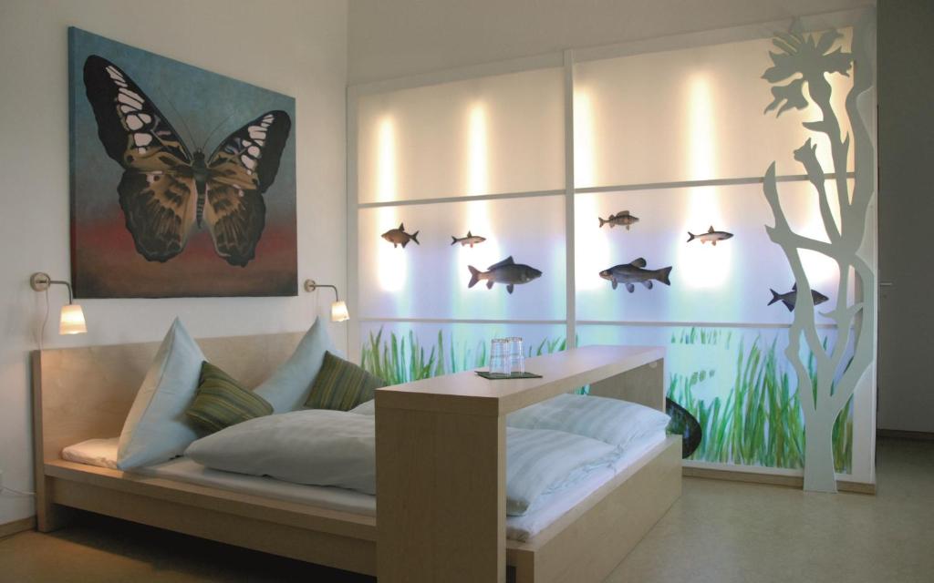 1 dormitorio con 1 cama con mariposas en la pared en Pension Spreewelten, en Lübbenau