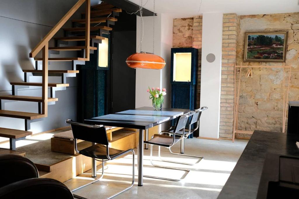 a dining room with a table and chairs and a staircase at Klimatisiertes Loft im Herzen von Deidesheim in Deidesheim