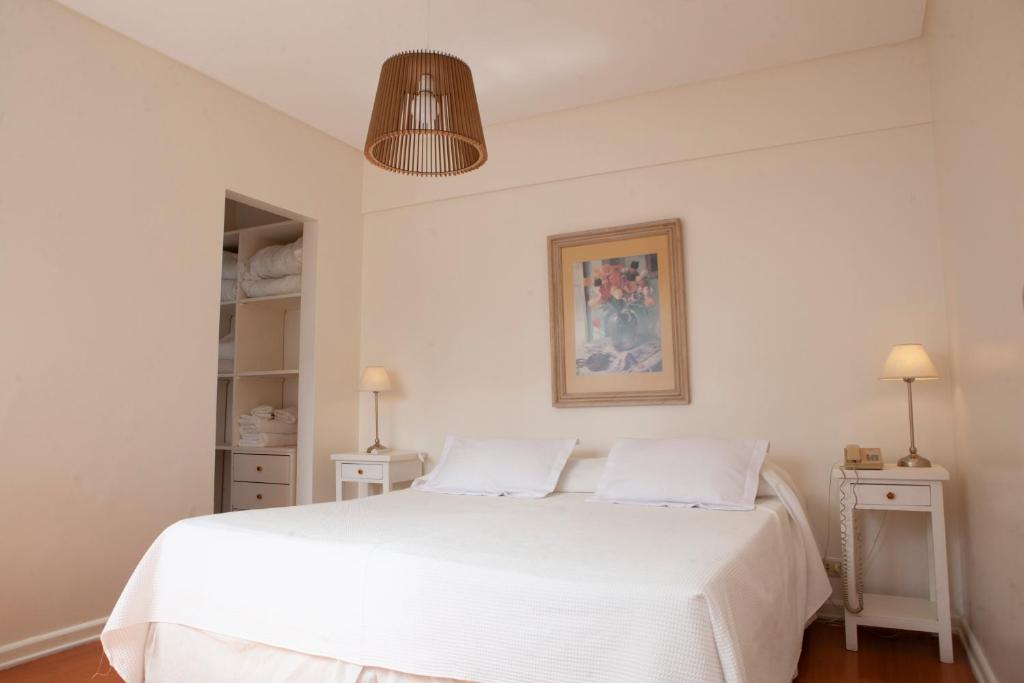 a bedroom with a white bed with two night stands at Apartamento Canciller in Buenos Aires