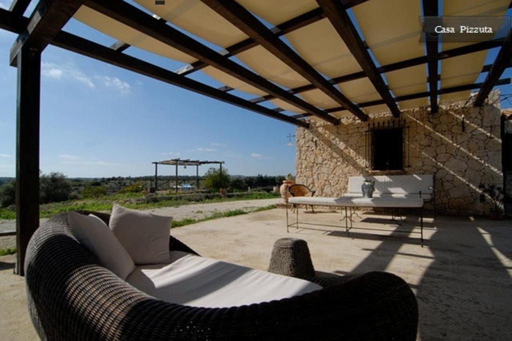 eine Couch auf einer Terrasse mit einem Tisch in der Unterkunft Casa Pizzuta in Noto