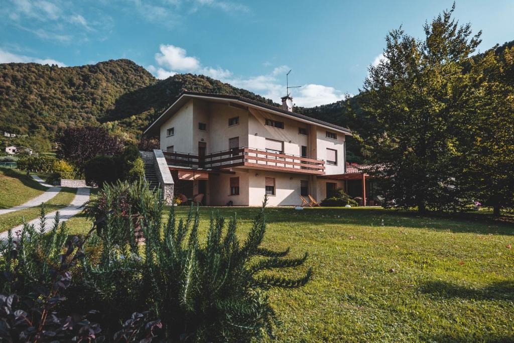 a large house on a hill with a grass yard at La Via Claudia Casa Vacanze in Valmareno