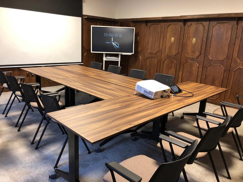 a conference room with a table and a projector screen at Penzion Bene in Chotěboř