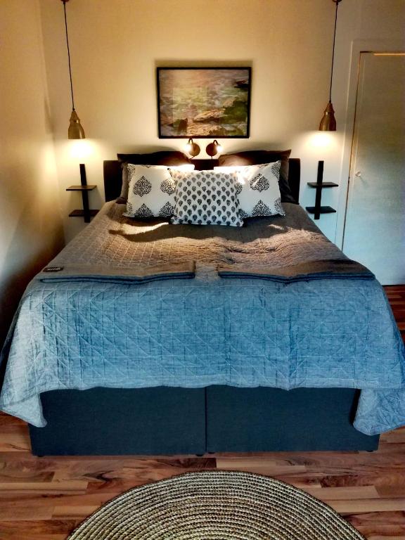 una camera da letto con un letto con un piumone blu di Gårdshuset a Söderhamn