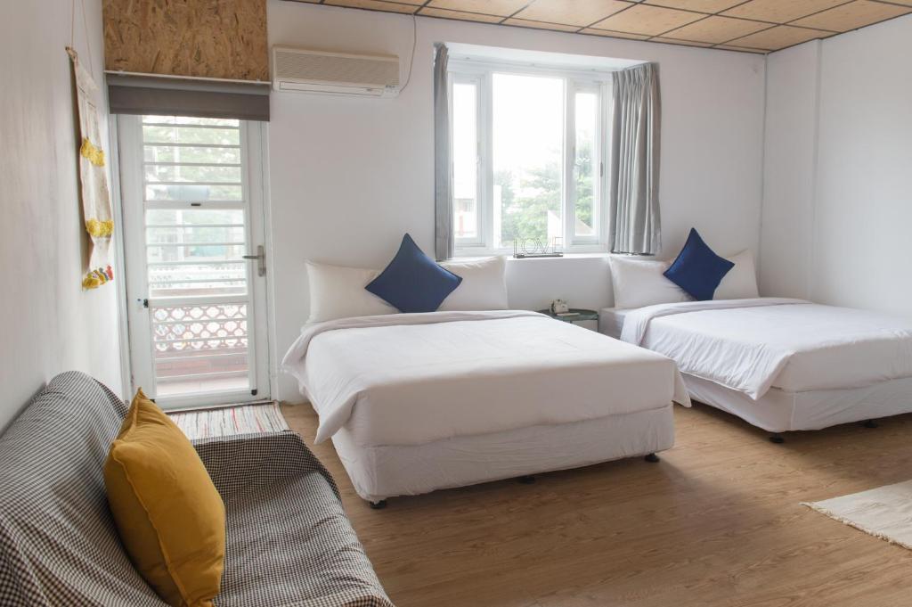a hotel room with two beds and a couch at HELLO Make Yourself at Home in Kenting