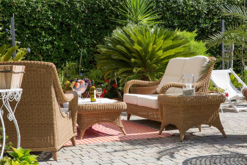 een patio met rieten stoelen en een tafel bij Villa I Poggioli in Bocca di Magra