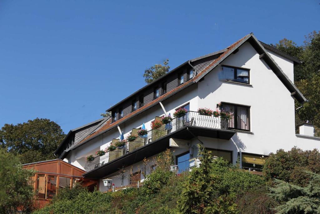 una casa en una colina con flores en los balcones en Landgasthaus Rothbrust, en Burgbrohl