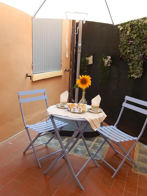 stół z dwoma krzesłami i wazon ze słonecznikiem w obiekcie La casa del Centro w mieście Modena
