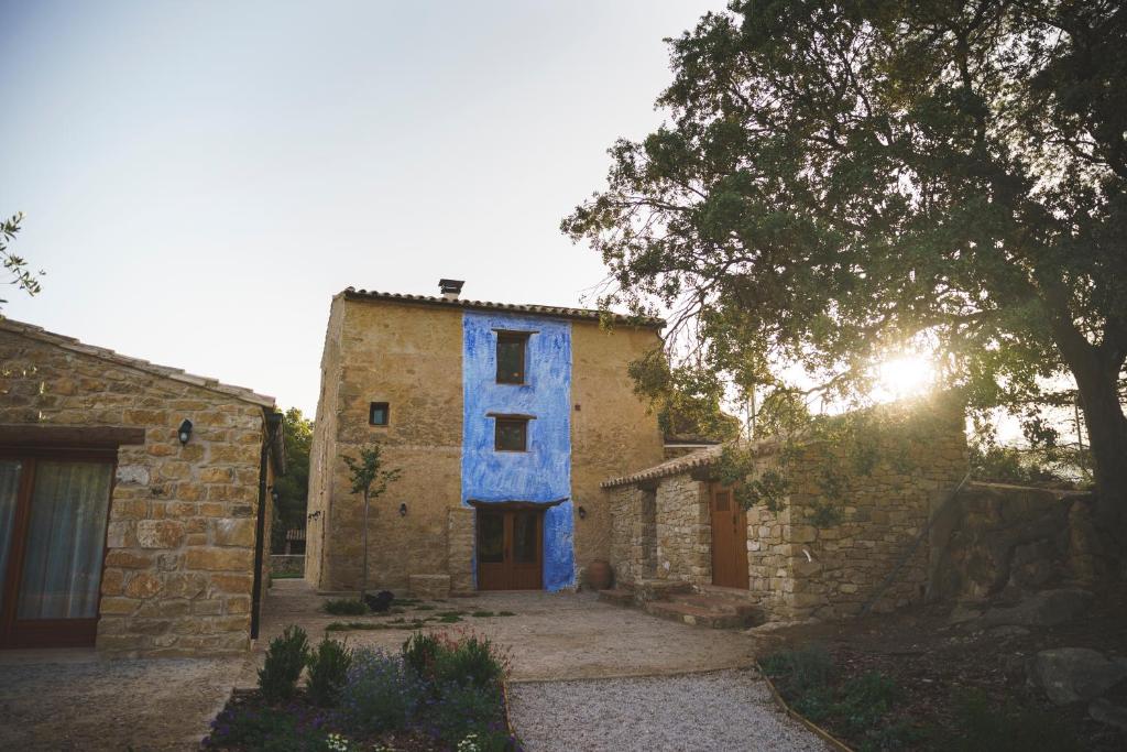 a building with blue paint on the side of it at Casa rural Mas del Serranet in Horta de San Joan