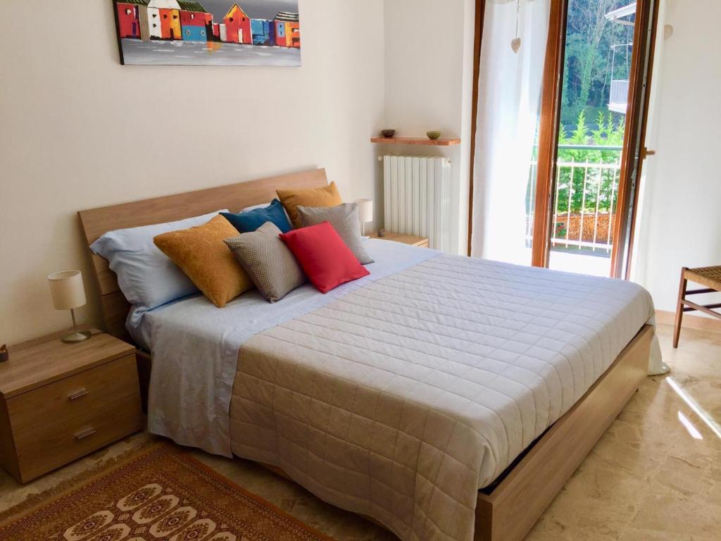 a bedroom with a large bed with colorful pillows at Casa Bianca in Frabosa Sottana