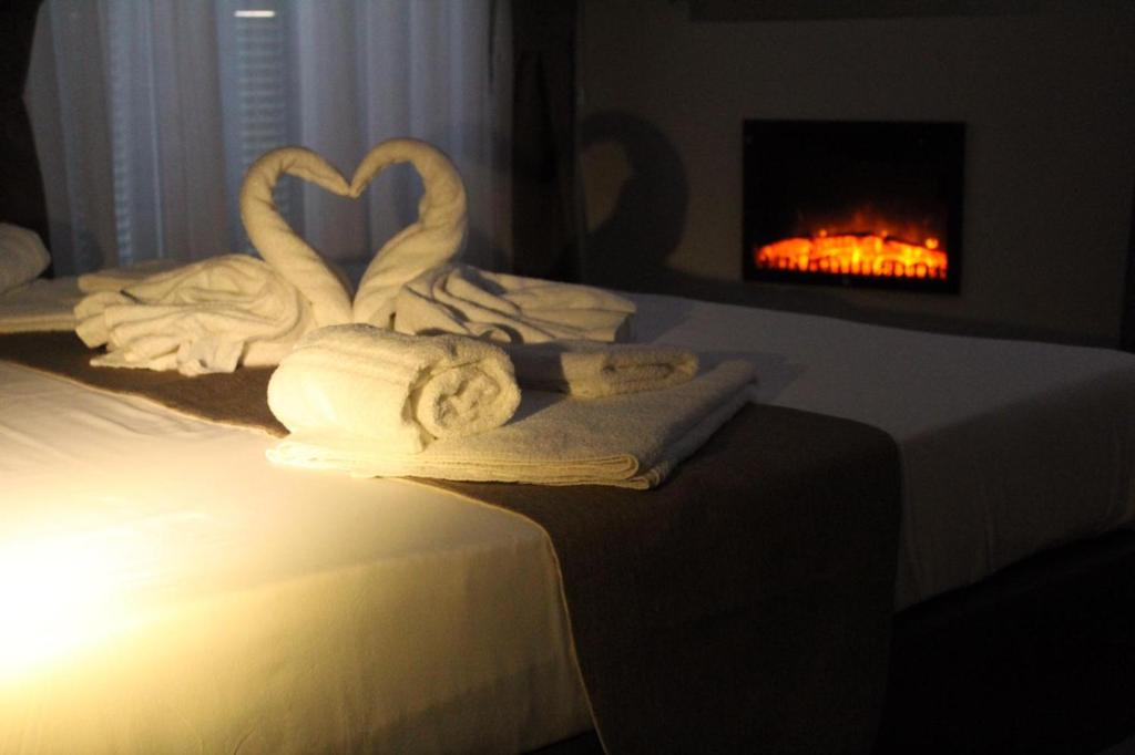 due cigni fatti di asciugamani su un letto con camino di Dante Relais a Napoli