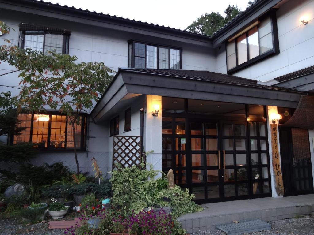 uma casa com um exterior preto e branco em Mizubasho no Yado Higashi em Katashina