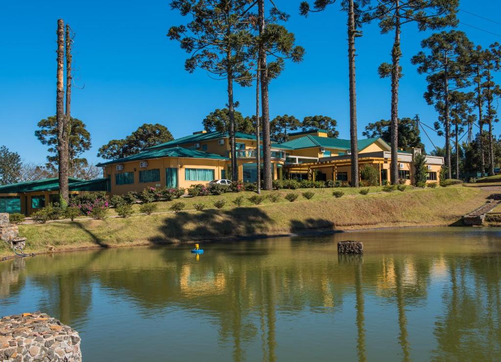a house with a lake in front of it at Lagoa Parque Hotel in Lagoa Vermelha