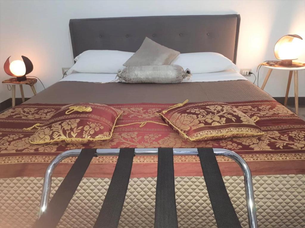 Una cama con marco de metal y almohadas. en Mary House, en Belvedere Marittimo