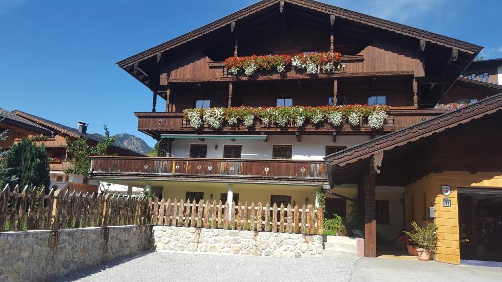 a building with potted plants on the side of it at Andreas Apartment im Landhaus Moser in Alpbach