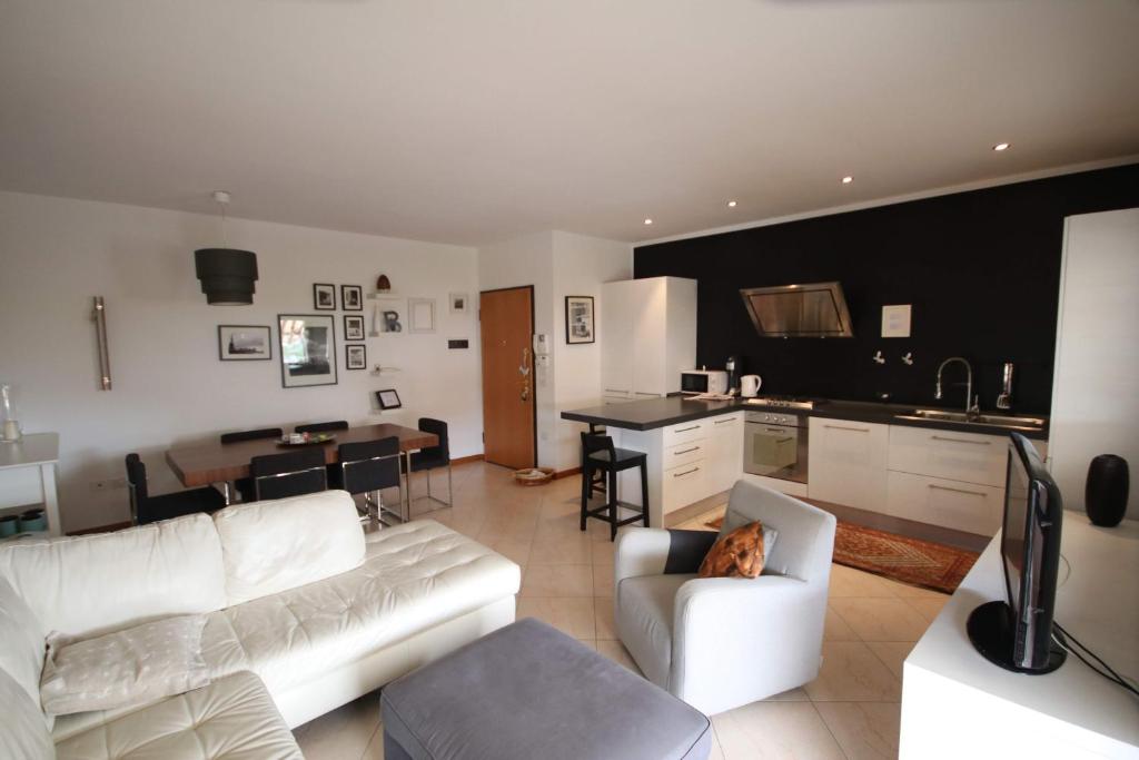 een woonkamer met een witte bank en een hond in een stoel bij Deluxe Padova Apartment in Rubano