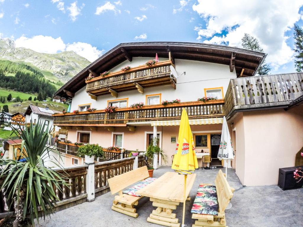 een huis in de bergen met een tafel en stoelen bij Haus Bergblick in Prägraten