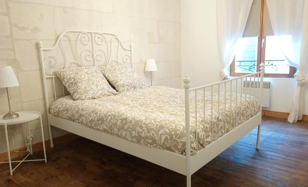 a white bed in a room with a window at Charmante Maison dans petite citée de caractère 13km du ZOO in Luché-Pringé