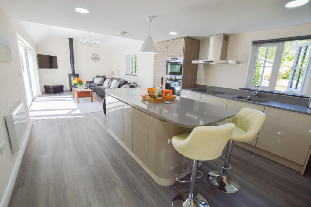 a kitchen and living room with a counter and chairs at Sunnyside Barn in Truro