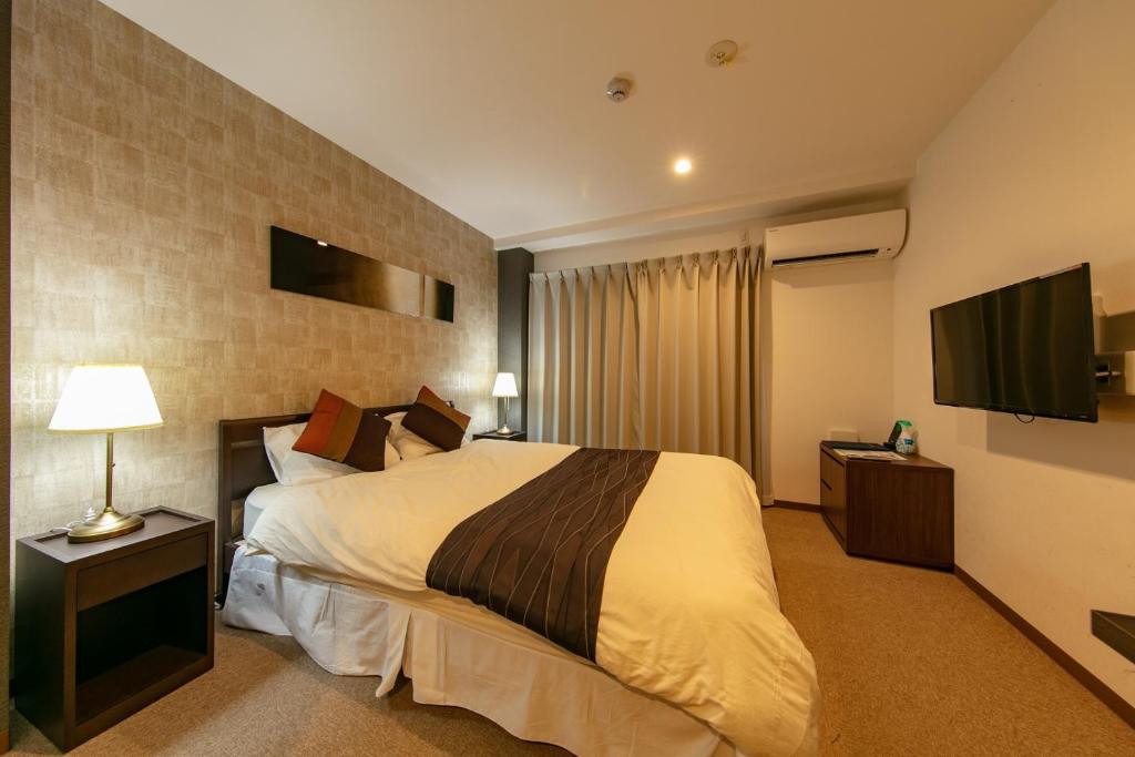 Habitación de hotel con cama y TV de pantalla plana. en Stay SAKURA Nihonbashi / Vacation STAY 51029, en Osaka