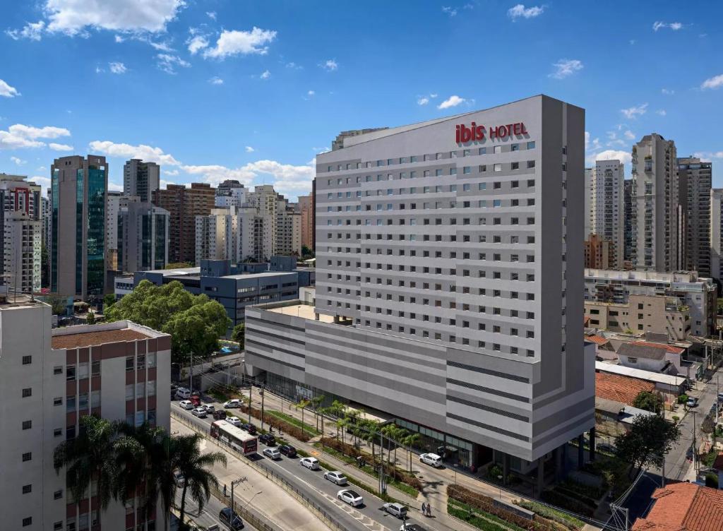 un edificio blanco alto con un signo kreme krispy en ibis Sao Paulo Ibirapuera, en São Paulo