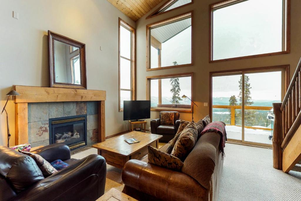 a living room with leather furniture and a fireplace at Arolla Chalet D in Big White