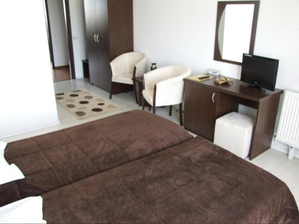 Cette chambre comprend un grand lit, un bureau et une chaise. dans l'établissement PLAISIR, à Ploieşti