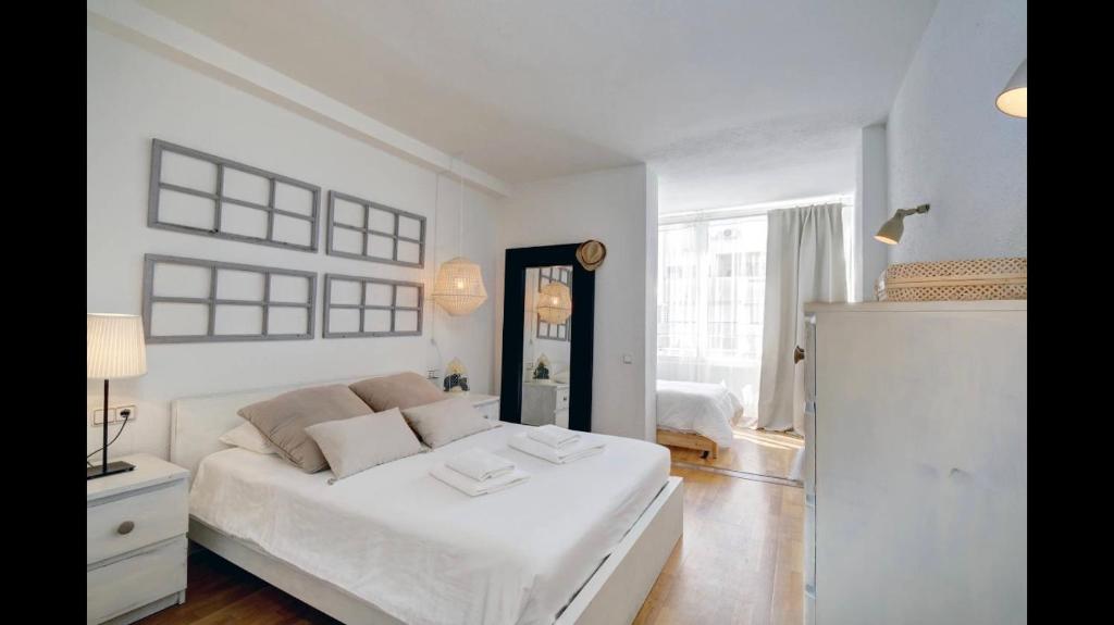 Un dormitorio blanco con una cama blanca y una ventana en Casa Valentuñana - Marbella Centro, en Marbella