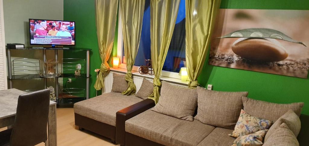 salon z kanapą i telewizorem w obiekcie Sonnige Ferienwohnung WHV w mieście Wilhelmshaven