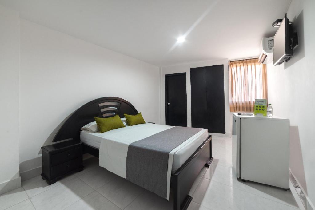 1 dormitorio con 1 cama y TV. en Hotel Olimpico, en Barranquilla