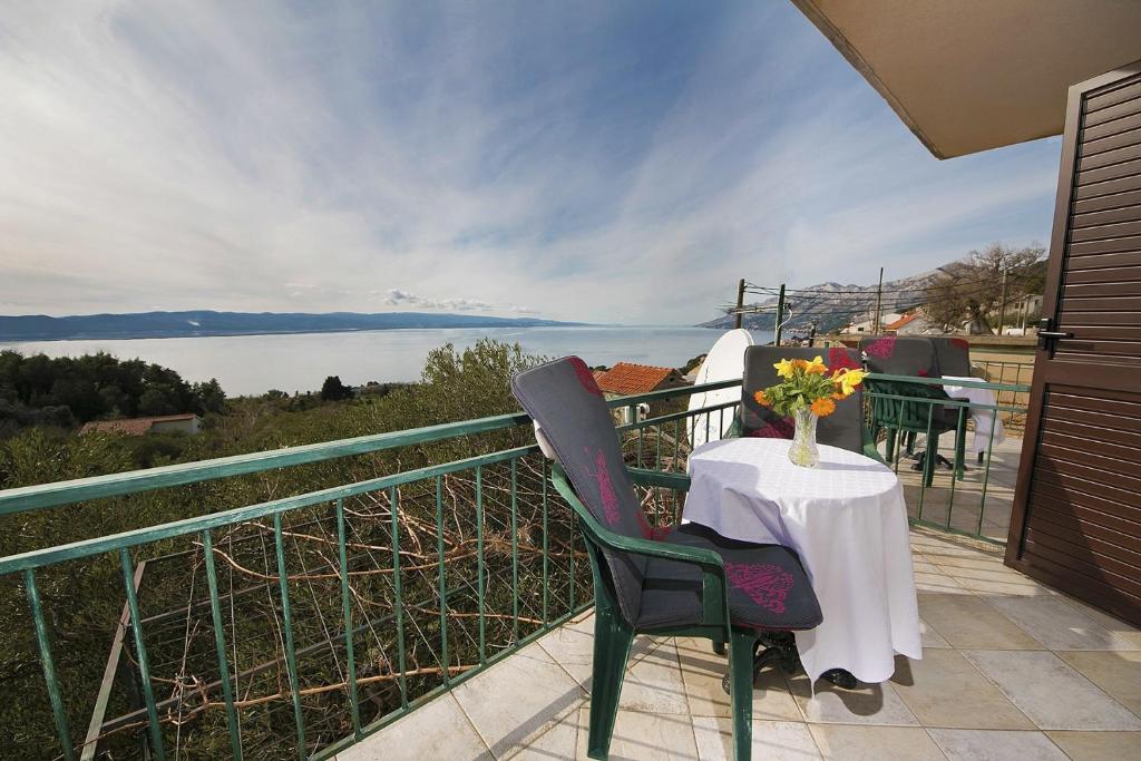 a table and chairs on a balcony with a view of the water at Apartment Panorama - terrace with sea view in Brela