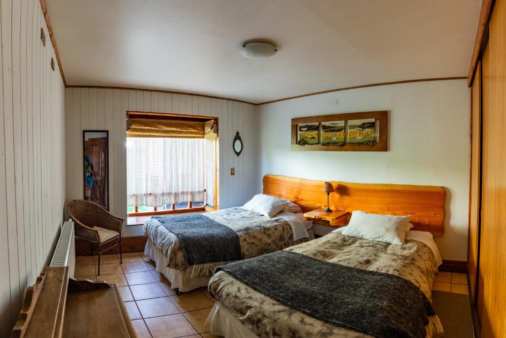 um quarto de hotel com duas camas e uma janela em B&B HMüller em Pucón