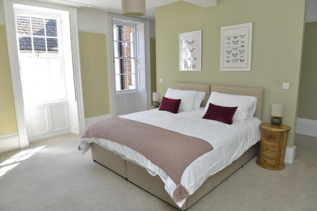 a bedroom with a large bed with red pillows at 10B Old green Chamber City center apartment, spacious and free parking! in St Ives