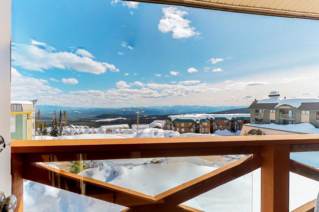 a view of the snow covered mountains from a balcony at Trappers Crossing 28 in Big White