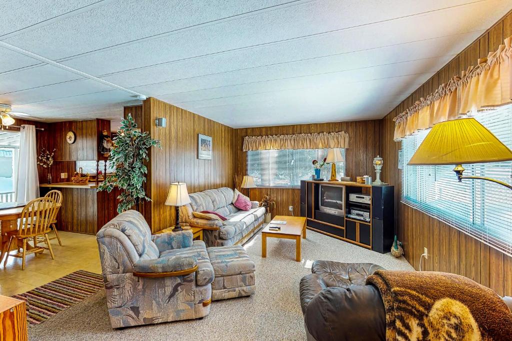 a living room with two couches and a table at Lazy Dayz Cottage in Christina