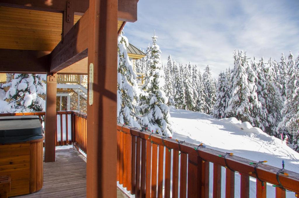 een veranda van een hut met sneeuw bedekte bomen bij Crystal View in Big White