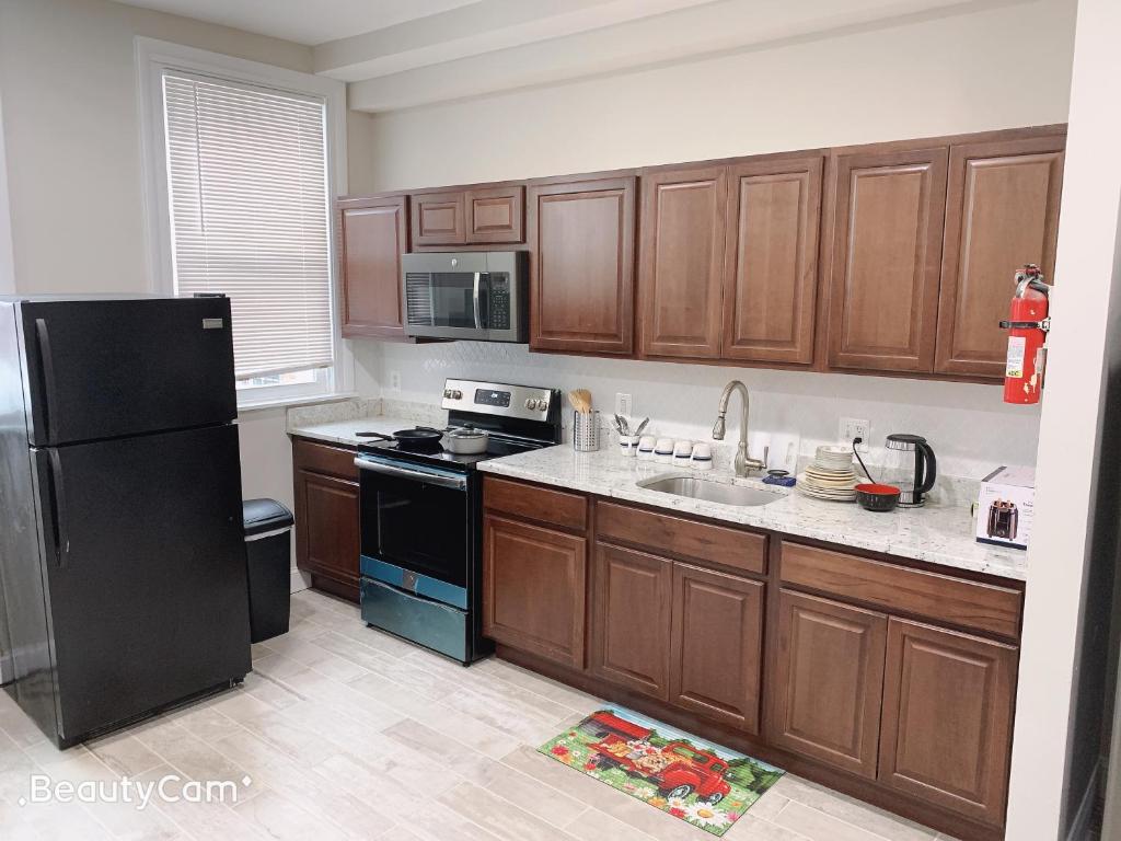 a kitchen with wooden cabinets and a black refrigerator at beautiful bedroom at central Baltimore in Baltimore