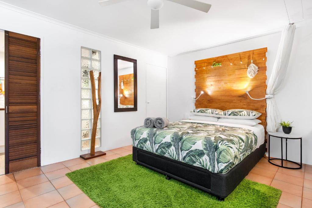 um quarto com uma cama e uma cabeceira em madeira em Funky, Central Studio em Noosa Heads
