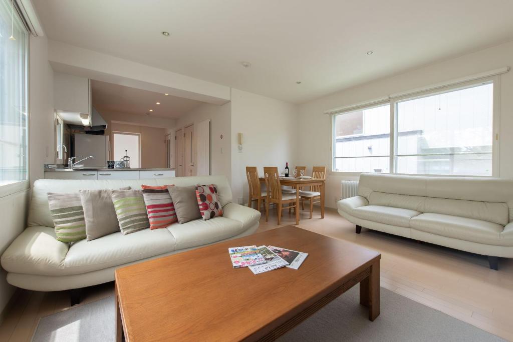 a living room with a couch and a table at Sakura Apartments in Kutchan