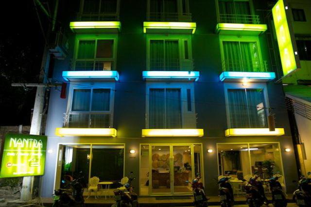 un bâtiment vert et bleu avec des motos garées devant lui dans l'établissement Nantra Chaweng Beach Hotel, à Chaweng