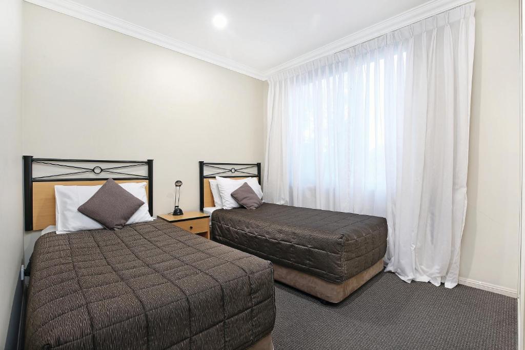 A bed or beds in a room at Wollongong Serviced Apartments