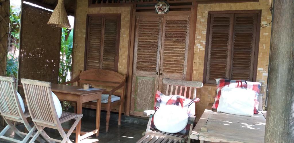 a cabin with two chairs and a table and a table at IDA'S Homestay in Candidasa