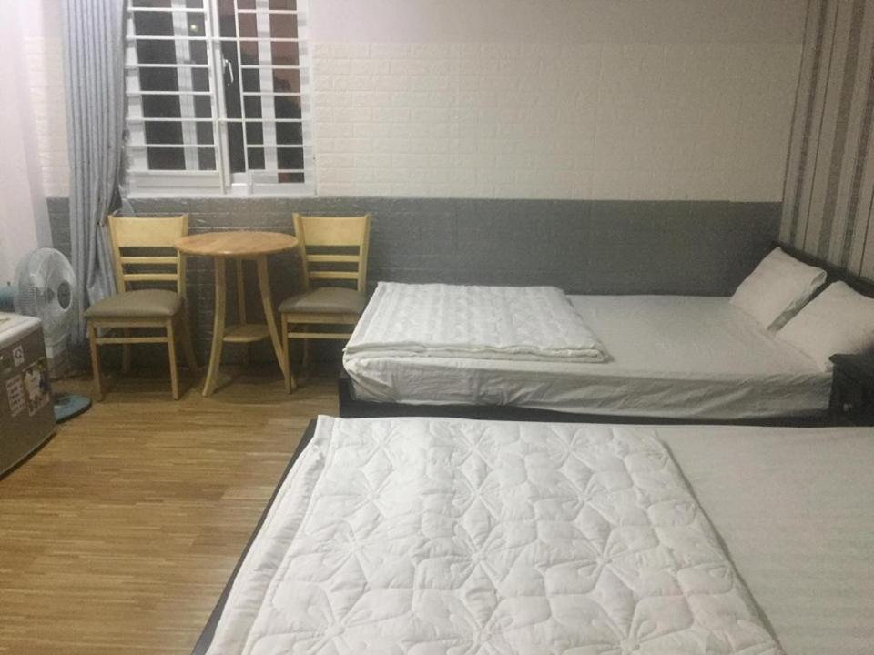 1 dormitorio con 2 camas, mesa y sillas en Phuong Thao Motel, en Da Nang